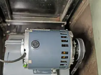 Blower motor assembly removed from a furnace for inspection